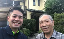 室内で年配の夫婦と若い男性が笑顔で写る記念写真
